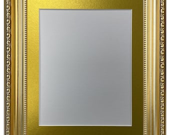 Puede incluir: Un marco de fotos rectangular con un acabado dorado ornamentado que presenta intrincados patrones en relieve a lo largo del borde exterior. El marco incluye un paspartú dorado ancho y liso que rodea un área de visualización central blanca.