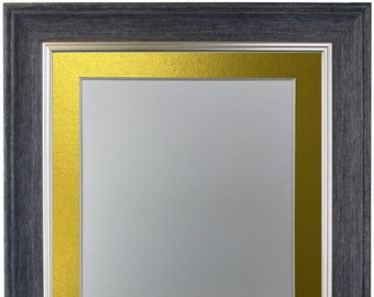 Può includere: Una cornice per foto in legno nero con un passepartout interno dorato. La cornice ha una bordura argentata.