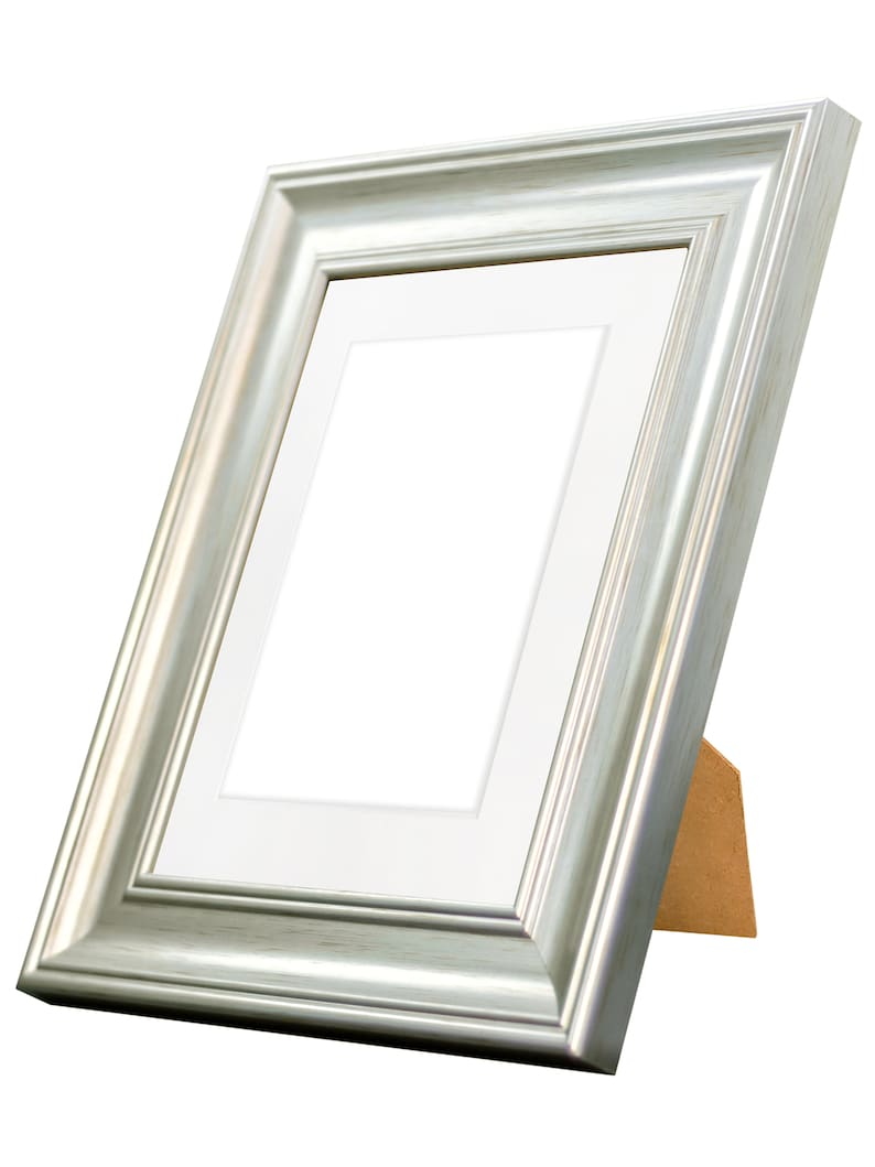 May include: A silver picture frame with a white mat and a wooden easel stand.
