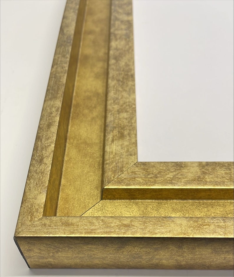 May include: Close-up of a corner of a gold picture frame with a distressed finish. The frame has a double-layered molding.