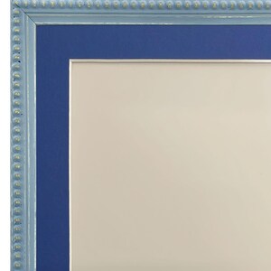 Pu&ograve; includere: Una cornice per foto blu con una cornice esterna blu chiaro e un bordo di perline dorate. La cornice &egrave; vuota.