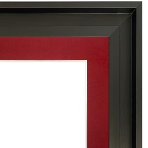 K&ouml;nnte beinhalten: Eckansicht eines schwarzen Bilderrahmens mit rotem Passepartout und wei&szlig;em Innenraum. Der Rahmen hat ein mehrschichtiges Design mit einem dicken schwarzen Rand und einem vertieften roten Passepartout. Der wei&szlig;e Innenraum ist bereit f&uuml;r ein Foto oder Kunstwerk.