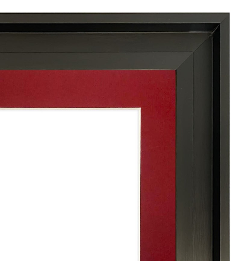 K&ouml;nnte beinhalten: Eckansicht eines schwarzen Bilderrahmens mit rotem Passepartout und wei&szlig;em Innenraum. Der Rahmen hat ein mehrschichtiges Design mit einem dicken schwarzen Rand und einem vertieften roten Passepartout. Der wei&szlig;e Innenraum ist bereit f&uuml;r ein Foto oder Kunstwerk.