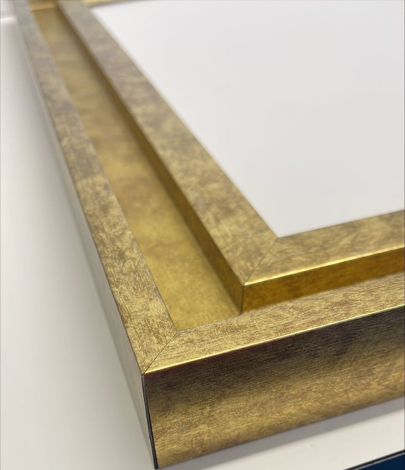 K&ouml;nnte beinhalten: Nahaufnahme eines goldenen Bilderrahmens mit doppelter Passepartout. Der Rahmen hat eine abgenutzte Oberfl&auml;che und einen leicht erh&ouml;hten Rand.