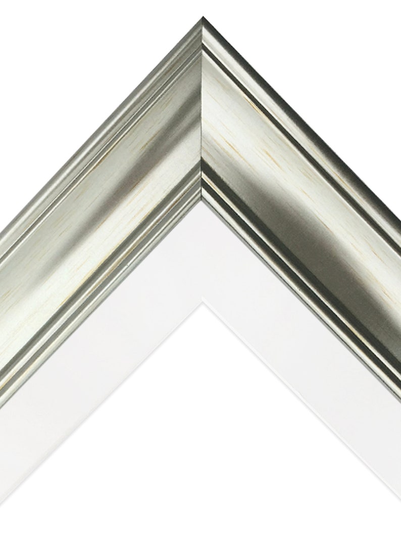May include: Close-up of a corner of a silver picture frame with a white mat. The frame has a slightly distressed finish.
