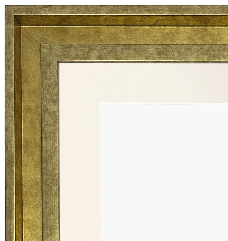 Puede incluir: Primer plano de la esquina de un marco de imagen dorado con un passe-partout blanco.