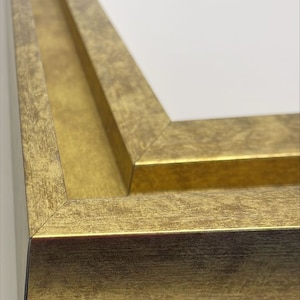 May include: Close-up of a gold picture frame with a beveled edge and a distressed finish.