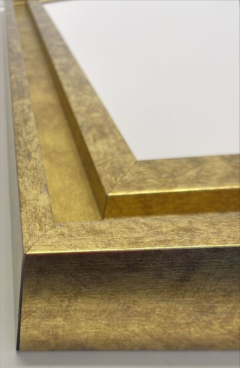 May include: Close-up of a gold picture frame with a beveled edge and a distressed finish.