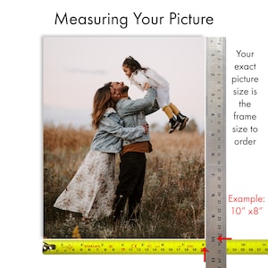 May include: A family of three poses for a photo in a field. A ruler is placed next to the image to show the exact size of the photo. The text "Your exact picture size is the frame size to order" is written next to the ruler. The text "Example: 10" x 8" " is written below the ruler.