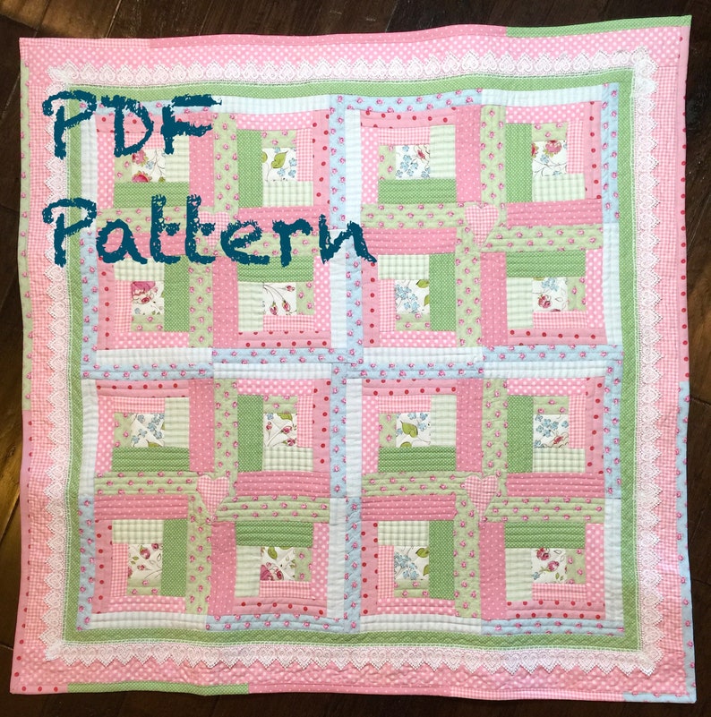 May include: A PDF pattern for a quilt with a log cabin design. The quilt is made with pink, green, and blue fabrics with floral and polka dot patterns. The quilt is edged with white lace.