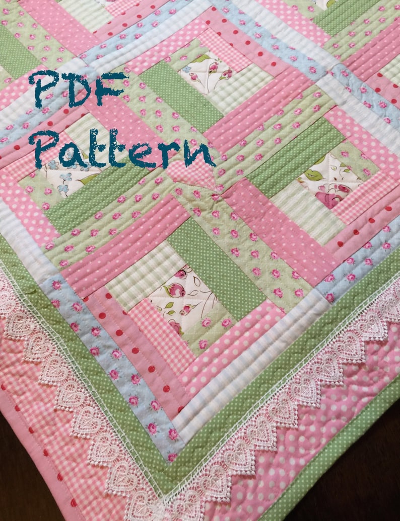 May include: A pink and green patchwork quilt with a white lace trim. The quilt is made of various fabrics with floral and polka dot patterns. The text "PDF Pattern" is written in black on the quilt.