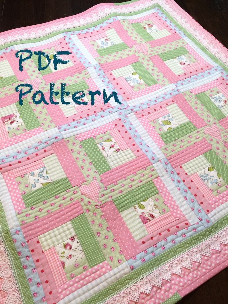 May include: A PDF pattern for a quilt with a patchwork design. The quilt is made with pink, green, and blue fabrics with various patterns, including polka dots, stripes, and floral prints. The quilt is edged with white lace.
