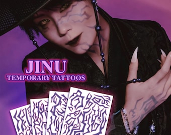 May include: Image featuring temporary tattoos with a dark purple design. The image includes the text "JINU TEMPORARY TATTOOS". The tattoos are displayed on white cards. The background is a gradient of purple and pink.