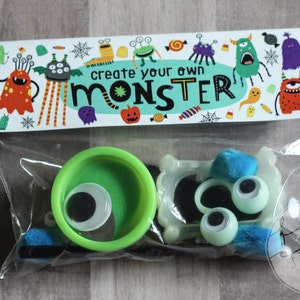 May include: A clear plastic bag filled with craft supplies for making a monster. The bag has a label that says "create your own monster". The supplies include googly eyes, pipe cleaners, felt, and a green plastic container.