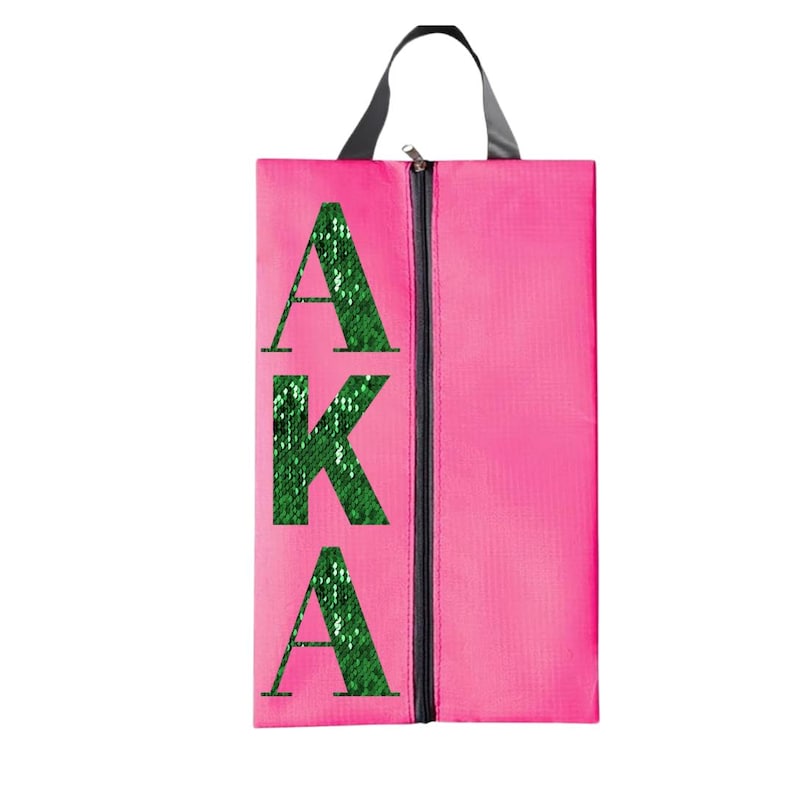 K&ouml;nnte beinhalten: Rosa Schuhbeutel mit Rei&szlig;verschluss und einem gr&uuml;nen Pailletten-Design mit der Aufschrift "AKA".