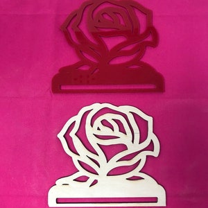 May include: Two wooden rose-shaped napkin holders, one red and one natural wood.