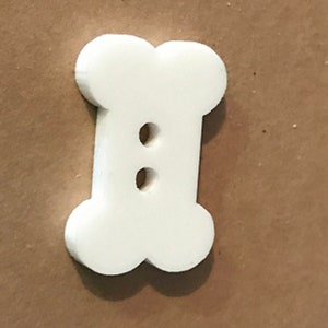 May include: White bone-shaped button with two holes.