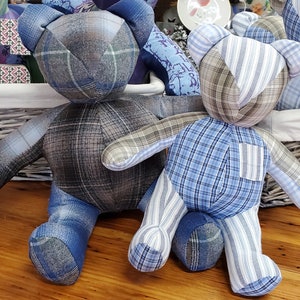 May include: Two patchwork teddy bears made from blue and white plaid fabric. The bears are sitting on a wooden surface.