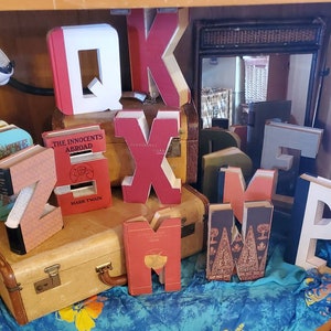 Letter book. Letters and shapes cut from hard backed books. Many colors and patterns in vintage Readers Digest to choose from.