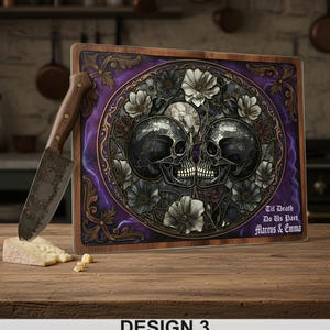 May include: A decorative cutting board with a skull design. The board features two skulls surrounded by flowers, with the text "Til Death Do Us Part Marcus & Emma". A knife and cheese are on the wooden surface.