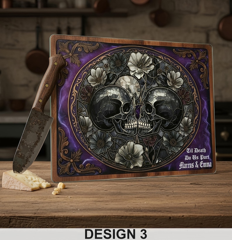May include: A decorative cutting board with a skull design. The board features two skulls surrounded by flowers, with the text "Til Death Do Us Part Marcus & Emma". A knife and cheese are on the wooden surface.
