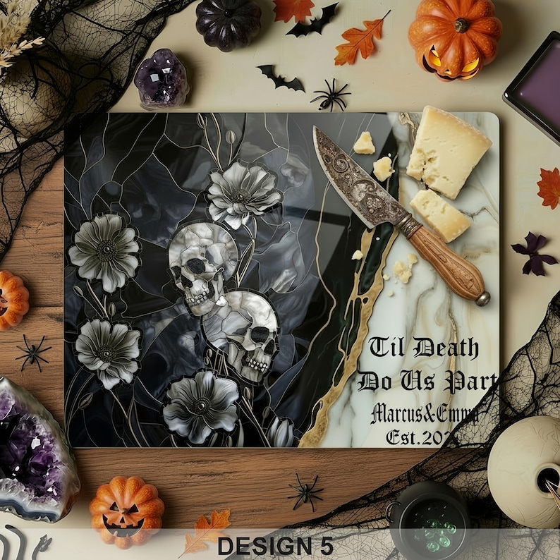 May include: A decorative cutting board with a skull and floral design, a cheese knife, and cheese. The board has the text "Til Death Do Us Part" and "Marcus & Emma Est. 2023". The design is in black, white, and gold.