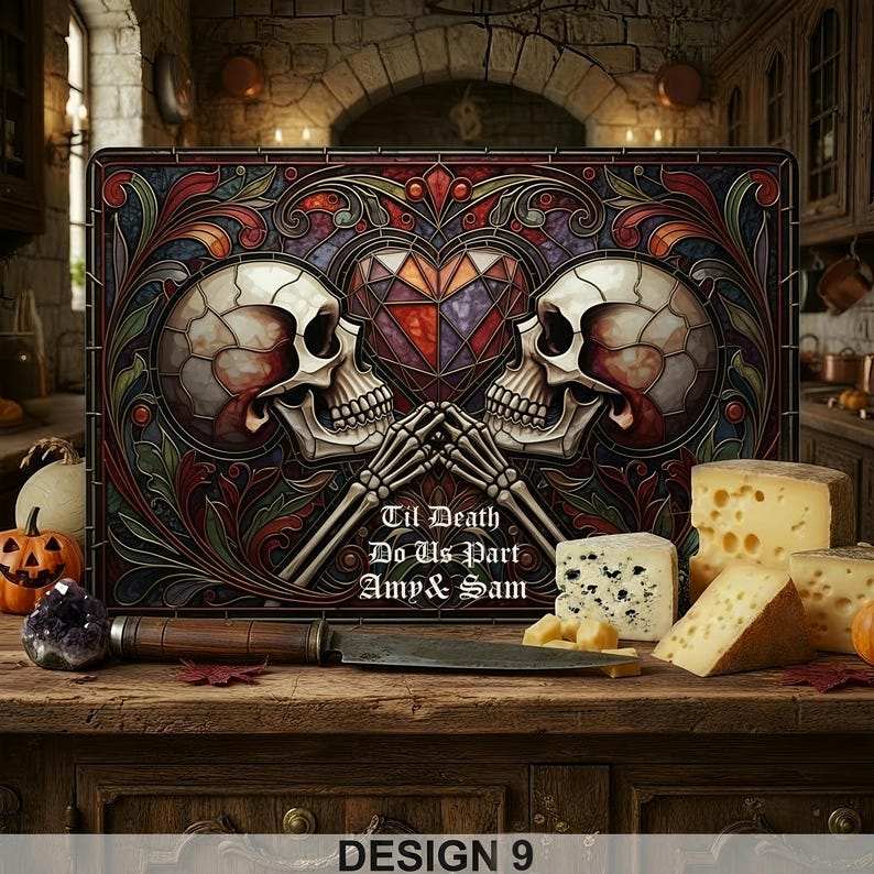 May include: A decorative cutting board with a stained glass design featuring two skulls, a heart, and the text "Til Death Do Us Part Amy & Sam." The board is surrounded by cheese, a knife, and a carved pumpkin. The words "DESIGN 9" are at the bottom.