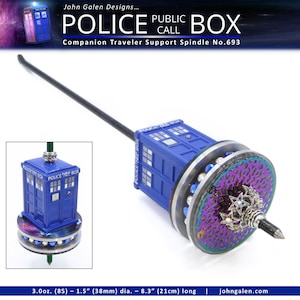 May include: A blue Police Box-themed spindle with a black shaft. The spindle features a miniature blue Police Box, a decorative wheel with purple and silver accents, and a silver metal tip. The text "POLICE BOX" is visible.
