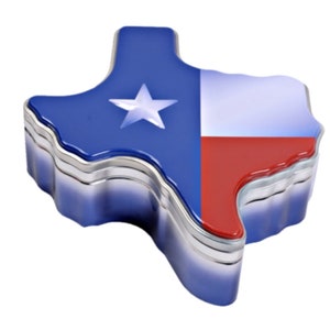 Puede incluir: Una caja de baratijas con forma de Texas con un borde plateado met&aacute;lico brillante. La parte superior est&aacute; dividida en dos secciones: un campo azul con una estrella blanca y una secci&oacute;n roja, blanca y azul, que refleja la bandera del estado de Texas.