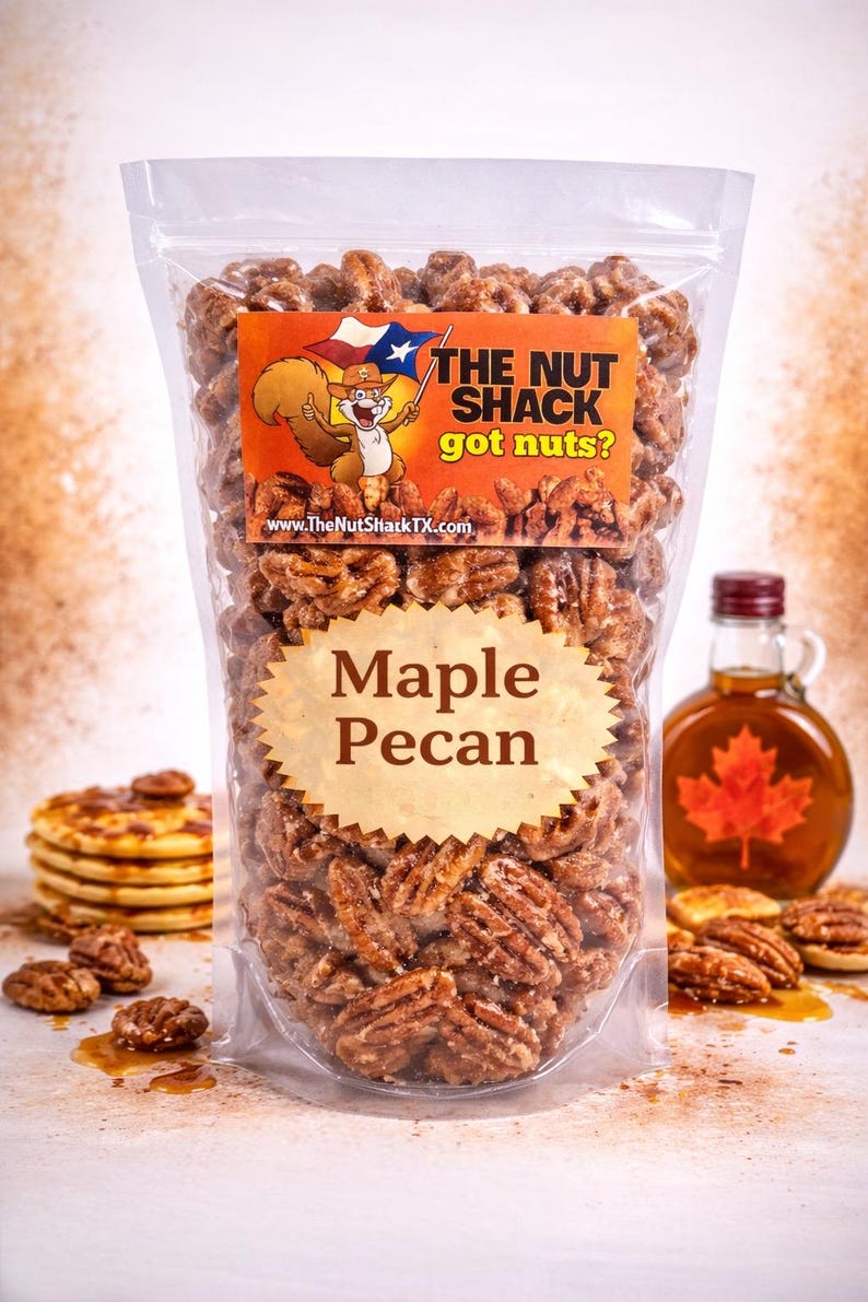 K&ouml;nnte beinhalten: Eine transparente Plastikt&uuml;te gef&uuml;llt mit Ahorn-Pekan-N&uuml;ssen. Das Etikett tr&auml;gt die Aufschrift "The Nut Shack got nuts?" mit einem Cartoon-Eichh&ouml;rnchen. Eine Flasche Ahornsirup und Pfannkuchen sind im Hintergrund zu sehen.