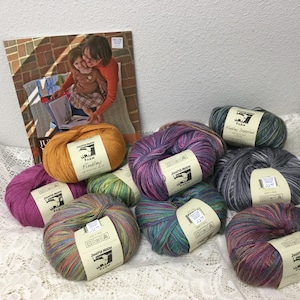 May include: Assortment of colorful yarn skeins in various shades of purple, blue, green, orange, and pink. The yarn is labeled "Jupiter Moon Farm" and "Findlay" with a sheep logo.