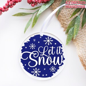 May include: A 2.5 inch diameter round blue and white Christmas ornament with the text "Let it Snow" and snowflakes.