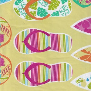May include: A repeating pattern of colorful flip-flops and tropical designs on a light yellow background. The flip-flops feature striped soles and bright straps. Other designs include floral and leaf motifs.