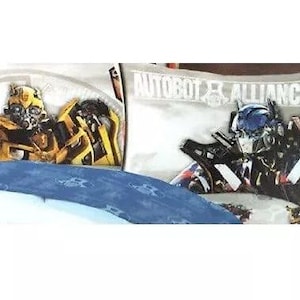 May include: A Transformers bedding set featuring a blue and silver robot and a yellow and black robot. The bedding is white with the text "Autobot Alliance".
