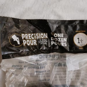 Pu&ograve; includere: Un sacchetto di plastica nero con la scritta "PRECISION POUR 3 BALL LIQUOR POUR ONE DOZEN POURS PORTION 1+ OUNCE SIZE" stampata su di esso. Il sacchetto contiene palline di plastica trasparenti.