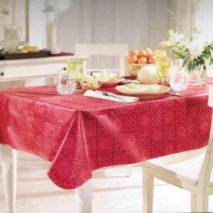 May include: A red tablecloth with a checkered pattern, set on a white table with a white chair. The table is set with a bowl of fruit, glasses, and plates.