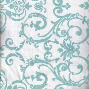 May include: White fabric with a repeating teal damask pattern. The design features scrolling vines, leaves, and floral elements. The fabric is likely used for home decor or apparel.
