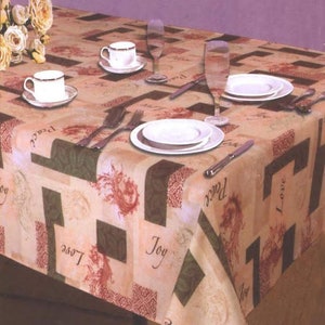 May include: A beige tablecloth with a repeating pattern of green, brown, and red squares. The words "Joy", "Love", and "Peace" are printed on the tablecloth. There are two white plates, two white cups, and two glasses on the tablecloth.
