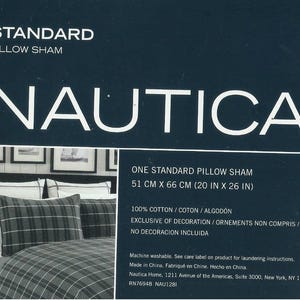 May include: A Nautica standard pillow sham, 20 inches by 26 inches, with a plaid pattern. The packaging includes the Nautica logo and text indicating it is made of 100% cotton. The pillow sham is machine washable.