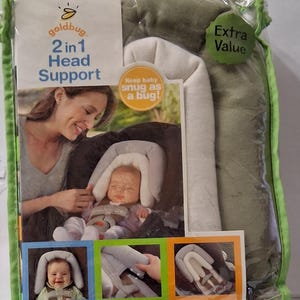 May include: A goldbug 2 in 1 Head Support in clear plastic packaging. The product is olive green and cream colored. The packaging features text including "2 in 1 Head Support", "Keep baby snug as a bug!", and "Extra Value" with images of the support in use.