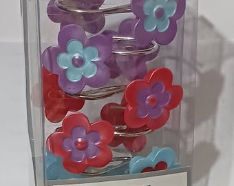 May include: A clear plastic box containing 12 resin shower hooks. The hooks are flower-shaped, with a mix of purple, red, and blue petals. The hooks are on silver-colored rings. The packaging has the text "Popular Bath".