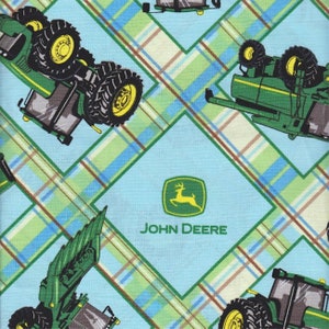 May include: Green and yellow John Deere tractor print fabric with a blue and white plaid background. The fabric features a repeating pattern of tractors and the John Deere logo.