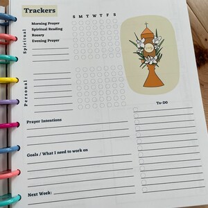 May include: A printable planner page with a daily tracker for spiritual and personal goals. The page includes sections for morning prayer, spiritual reading, rosary, evening prayer, prayer intentions, goals, and to-do list. The page also features a graphic of a religious symbol with the letters IHS.
