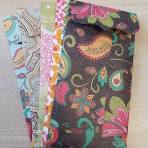 May include: A set of five colorful patterned envelopes with a paisley design. The envelopes are all different colors and patterns, but they all have a similar paisley design.