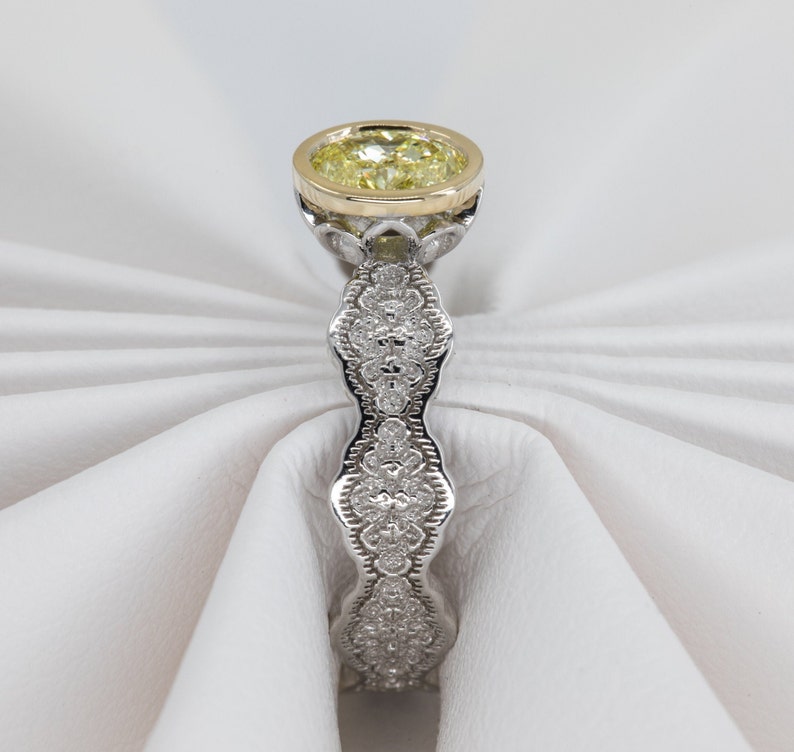 May include: A yellow diamond engagement ring with a delicate, intricate, and detailed band of pave set diamonds. The ring is set in white gold with a yellow gold setting for the center stone.