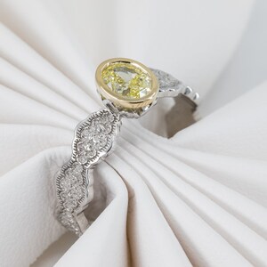 May include: A yellow oval gemstone ring with a gold setting and a white gold band. The band is decorated with small diamonds.