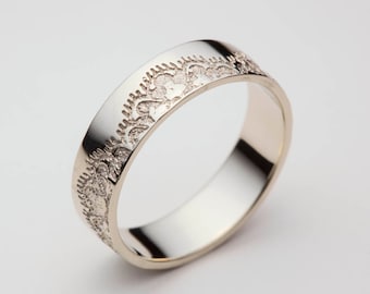 Puede incluir: Una alianza de plata con un diseño decorativo texturizado alrededor de toda la banda.