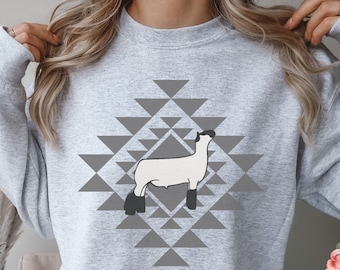 May include: A gray sweatshirt with a white sheep silhouette in a gray geometric pattern. The text "GILDAN 18000 ASH" is visible in the top left corner.
