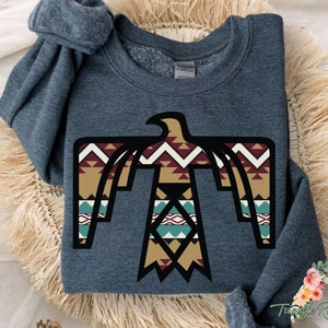 May include: Dark grey heather sweatshirt with a black and brown geometric eagle design. The eagle is stylized with a Native American inspired pattern.