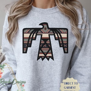 May include: A gray sweatshirt with a black and white geometric eagle design. The eagle is centered on the front of the sweatshirt. The text "DIRECT TO GARMENT PRINTING" is on the bottom right corner of the sweatshirt.